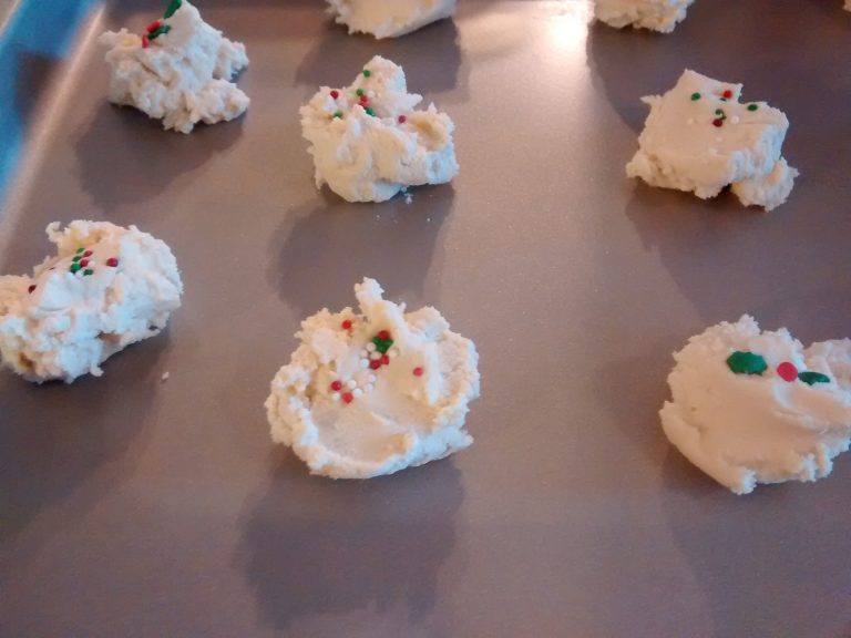 Dainty shortbread cookies with Christmas sprinkles, on baking sheet