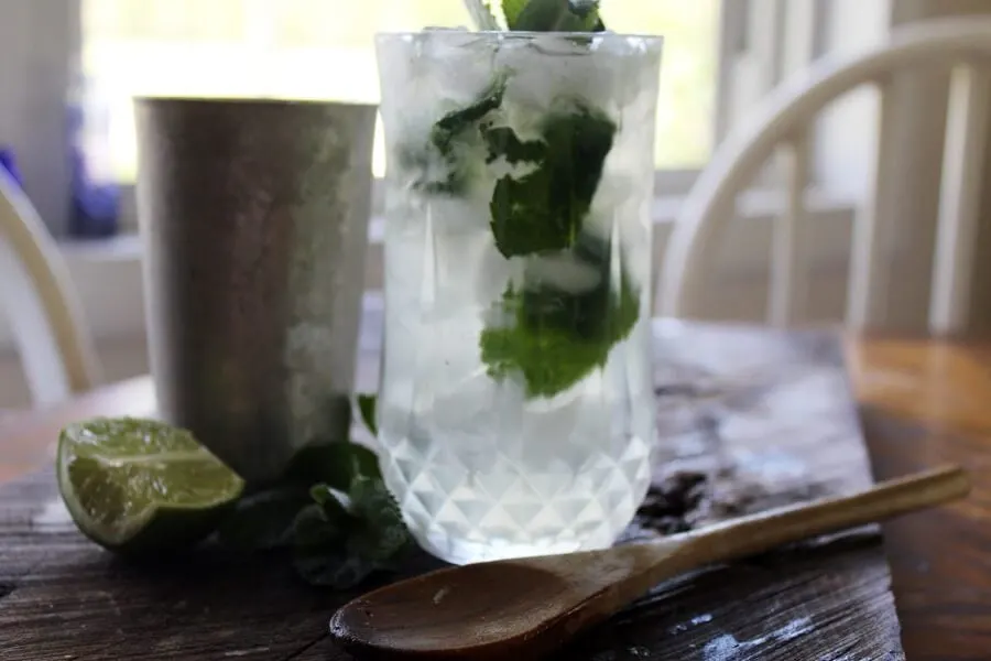 Fresh mojito in crystal glass on a cutting board with fresh mint and fresh lime