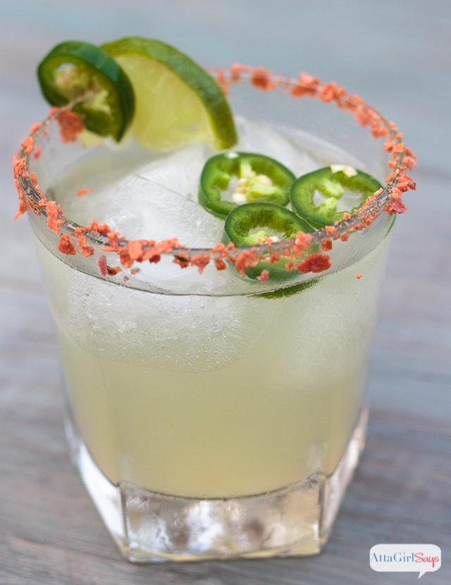 Bourbon glass filled with a spicy jalapeno bourbon, topped with fresh jalapeno slices and tortila chips