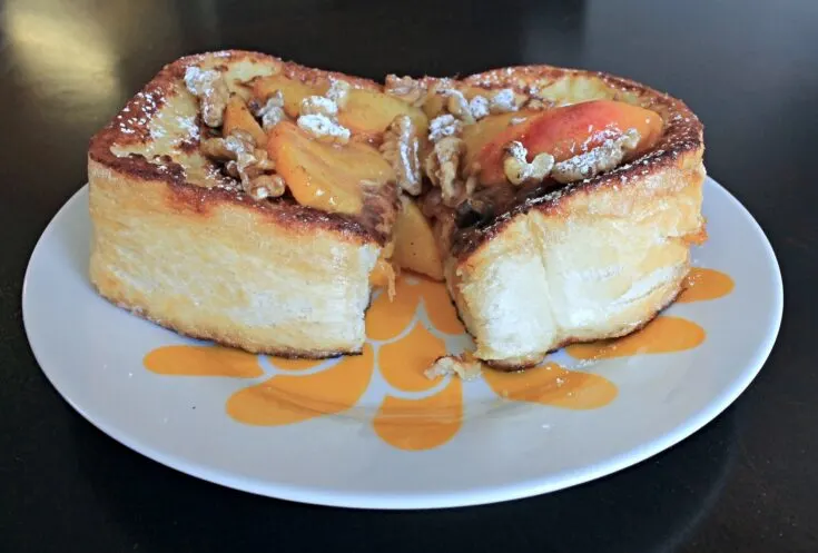 stuffed french toast sliced open on top of floral serving plate