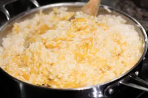 Squash risotto in skillet with wooden spoon ready to serve