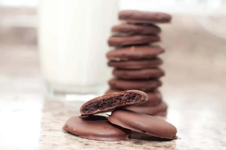 stacked cookies on counter with cup of milk