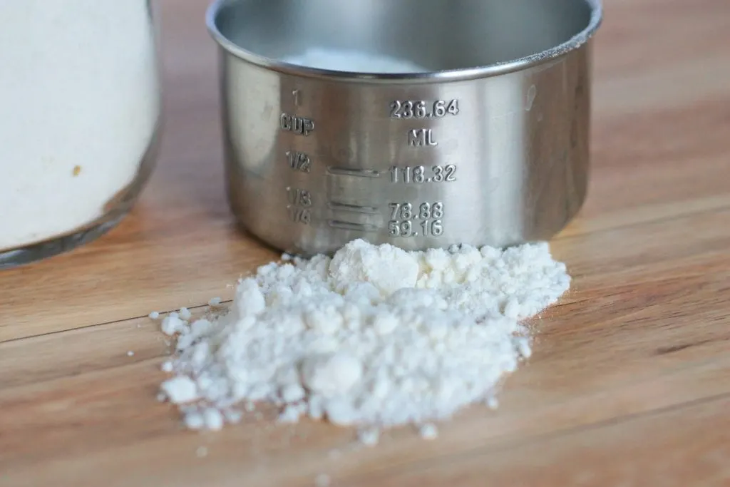 Measuring cup on table with bisquick mix.