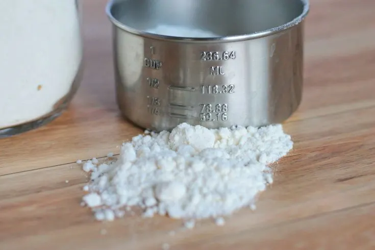 Measuring cup on table with bisquick mix.