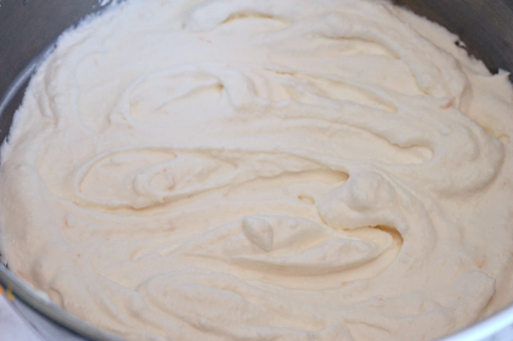 Mixing bowl full of orange ricotta cream for cake
