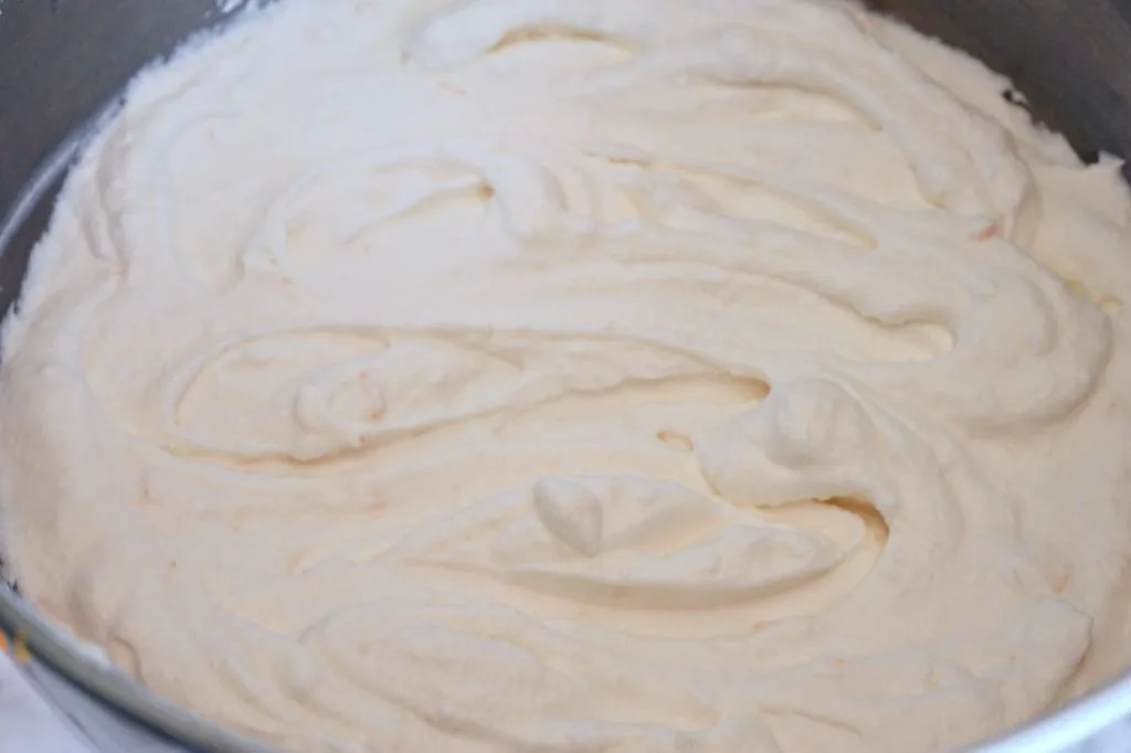 Mixing bowl full of orange ricotta cream for cake