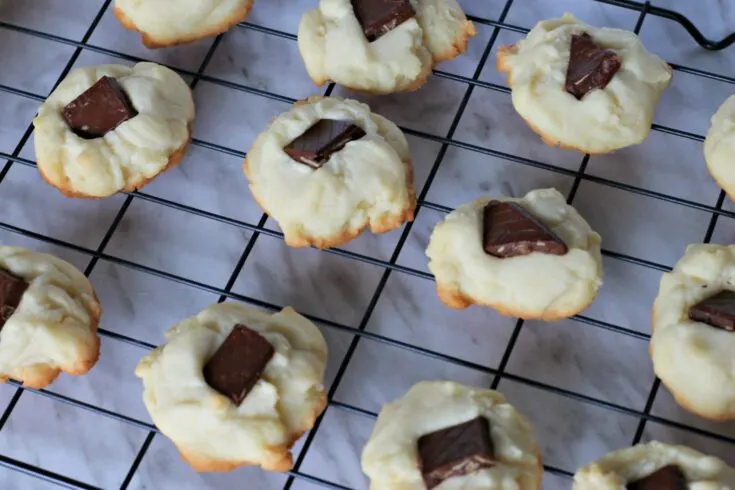 Cooling rack filled with whipped shortbread cookies on marble counter.