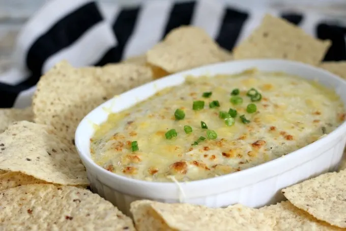 Cheesy Dill Pickle Dip in white bowl with corn chips