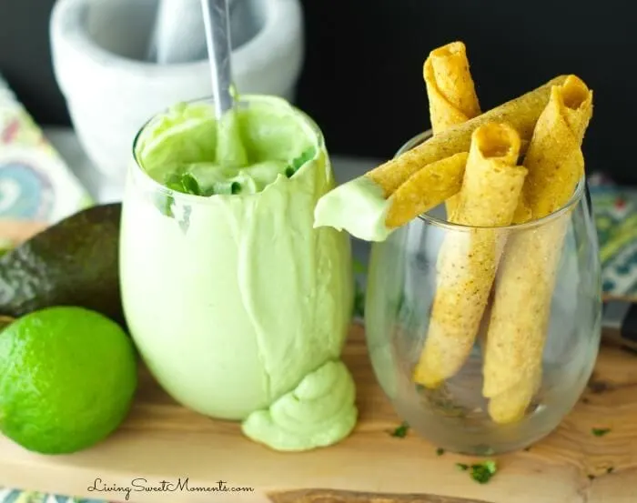 Glass of creamy avocado dip with rolled corn chips