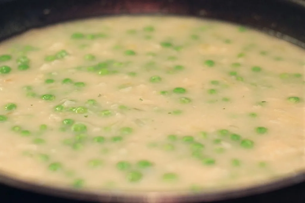 Sauce for Tuna Casserole with peas cooking in a saucepan.