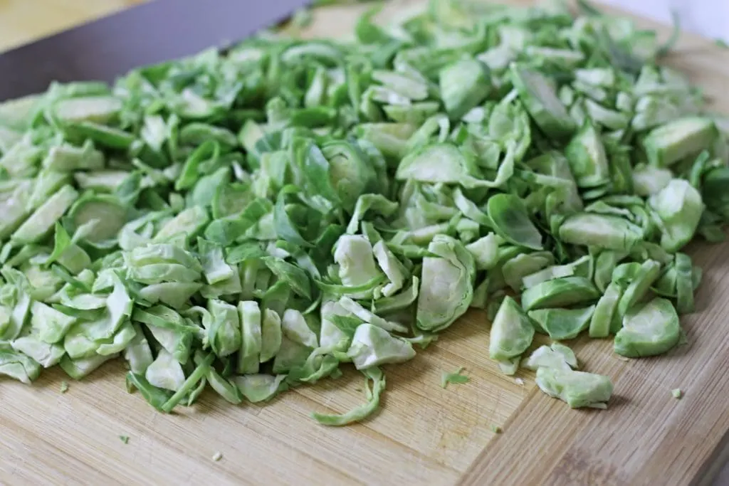 Shredded Brussel Sprouts on wooden cutting board for Salad