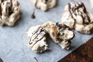 Meringue Cookies on parchment paper with chocolate drizzle
