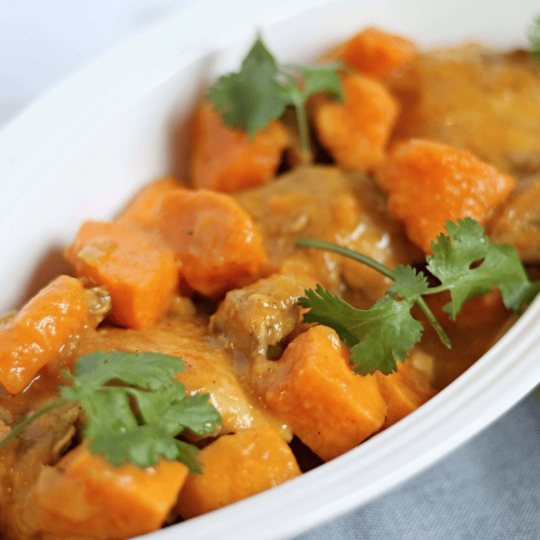 Chunky Moroccan chicken stew in a long white serving dish.