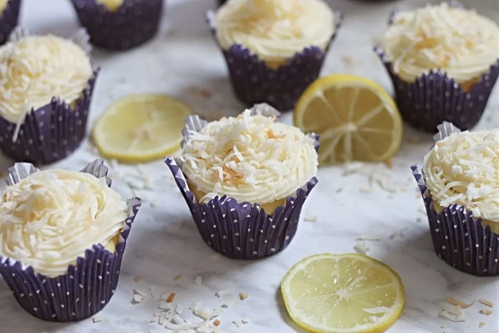 Lemon Cupcakes in purple cupcake liners on marble counter