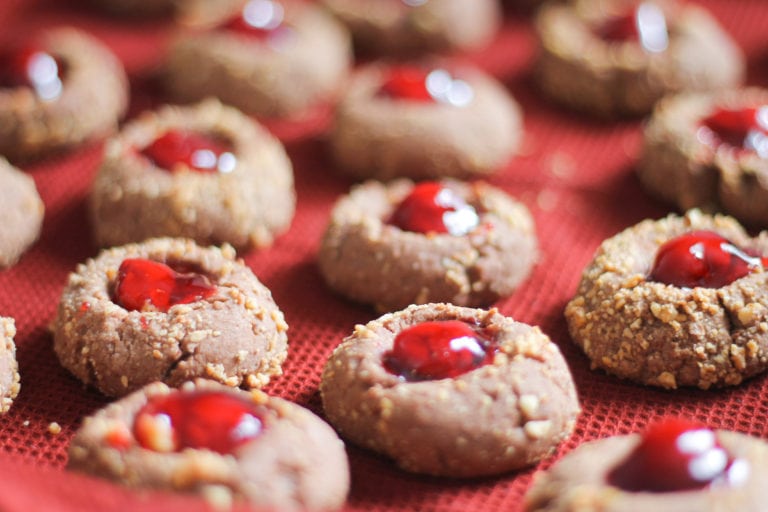 Red tablecloth lined with freshly baked Thumbprint cookies