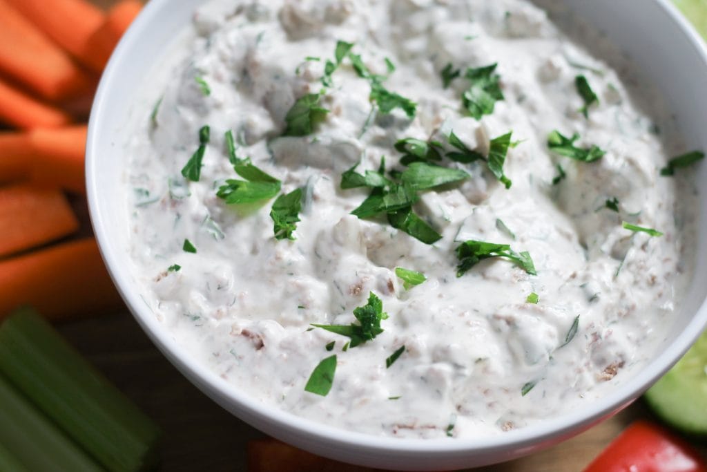 White bowl of corned beef dip with fresh parsley on top 