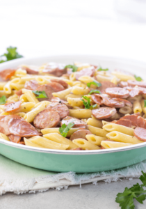 Large white bowl of pasta with sausage and pepperoni
