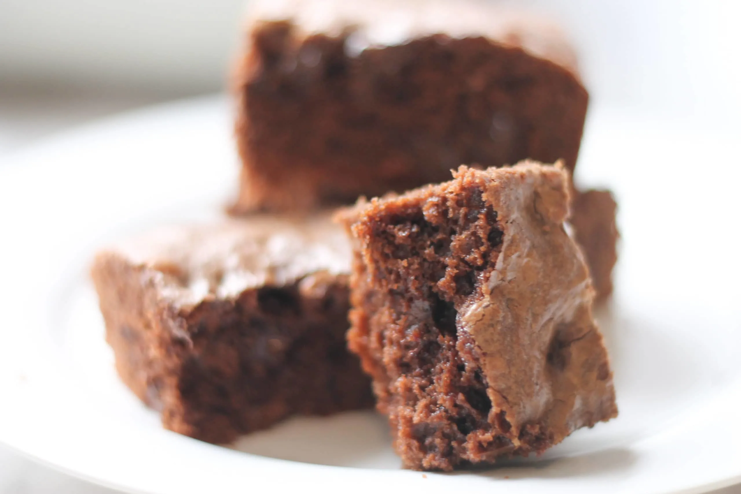 white plate with 3 stacked brownies