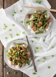 Two bowls of chicken and green beans stir-fry with chop sticks