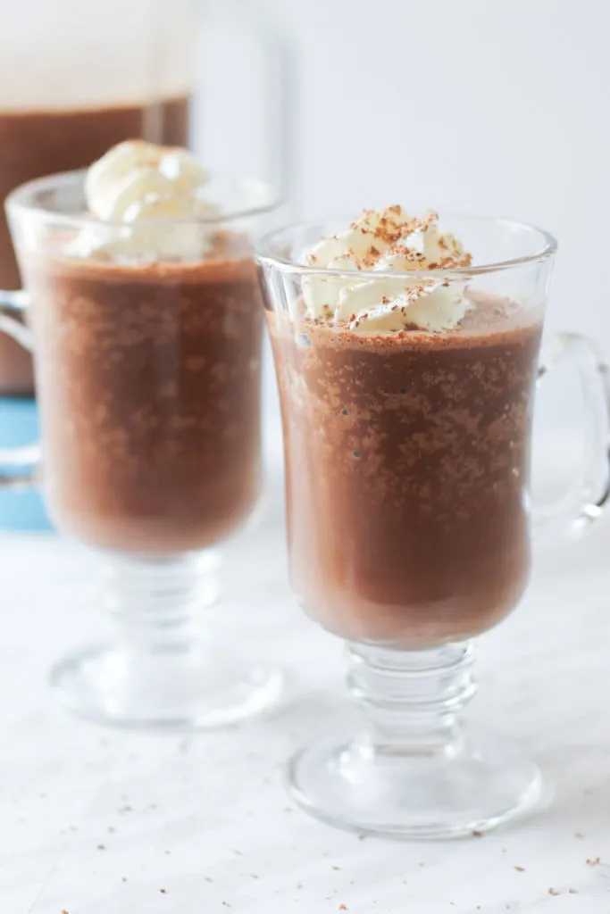 Two clear glasses of frozen hot chocolate with whipped cream on top 