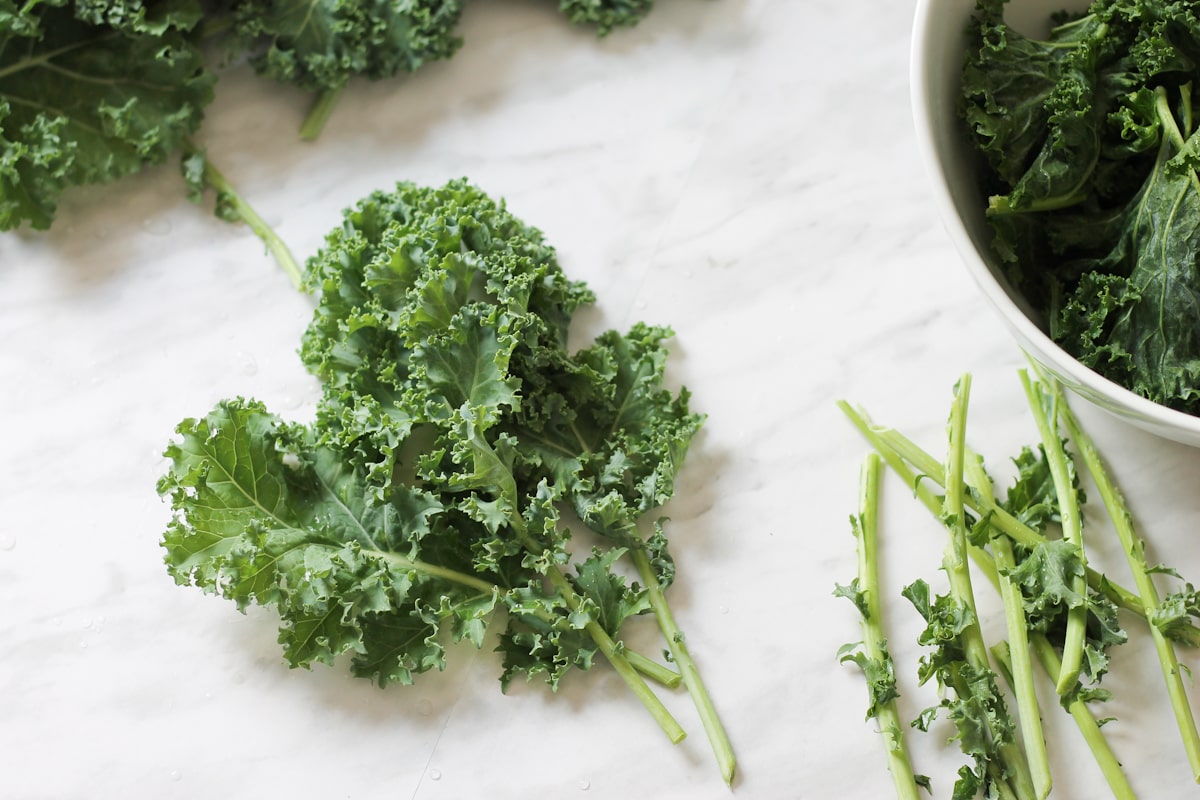 Kale leaves on marble counter top with stems removed