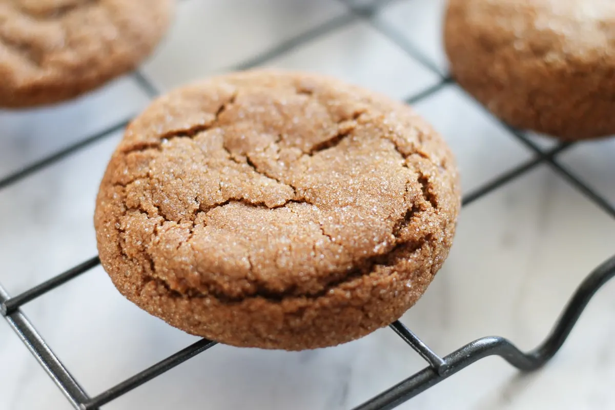 Fresh baked ginger molasses cookie on cooling rack.