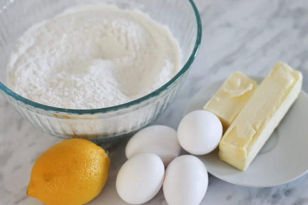 Ingredients for Lemon Cake on marble countertop.