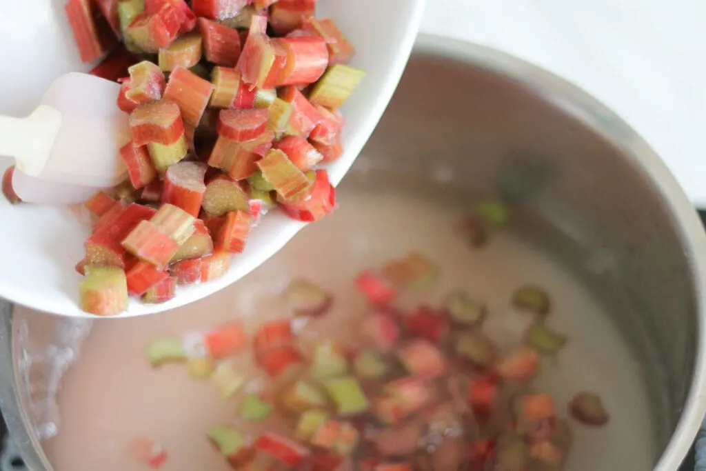 chopped rhubarb going into saucepan with water. 