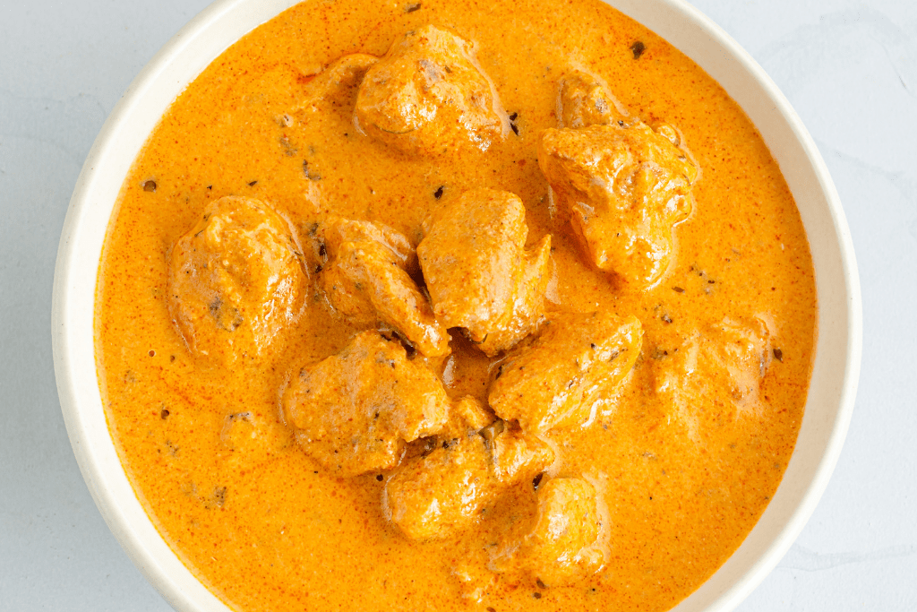 Large bowl of butter chicken.