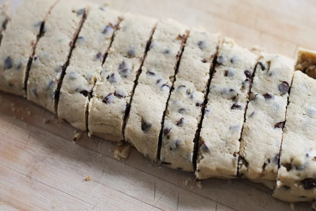 Sliced biscotti after first bake on wooden cutting board.