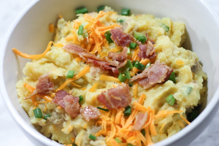 White ceramic bowl with loaded mashed potatoes.