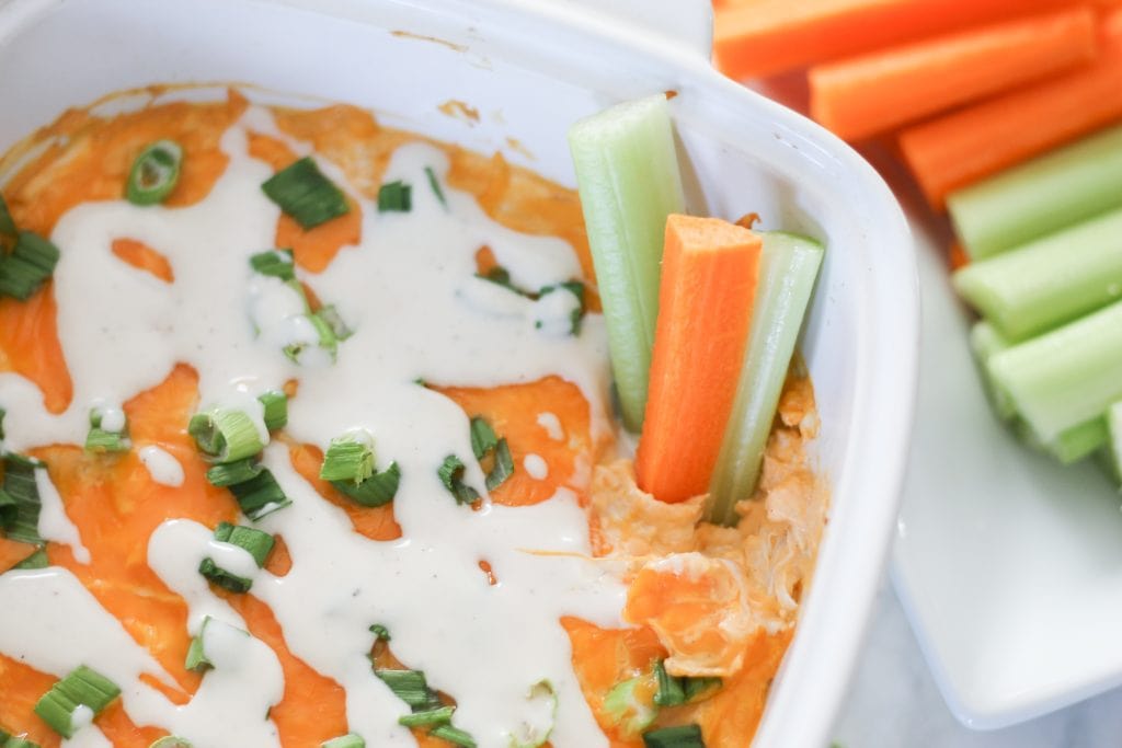 Finished buffalo dip with fresh carrot and celery sticks.